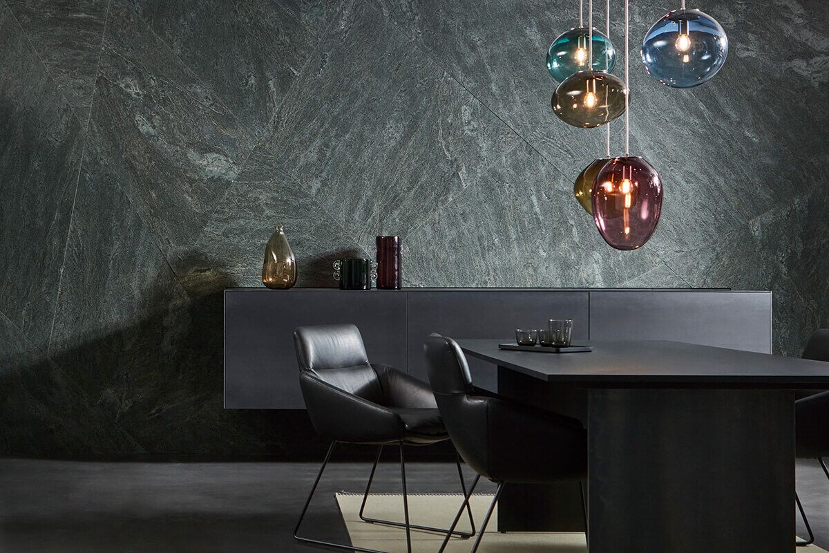 Acogedor, pero impecable. El revestimiento gráfico de la pared de granito Black Musk se combina con un aparador flotante hecho de acero negro.